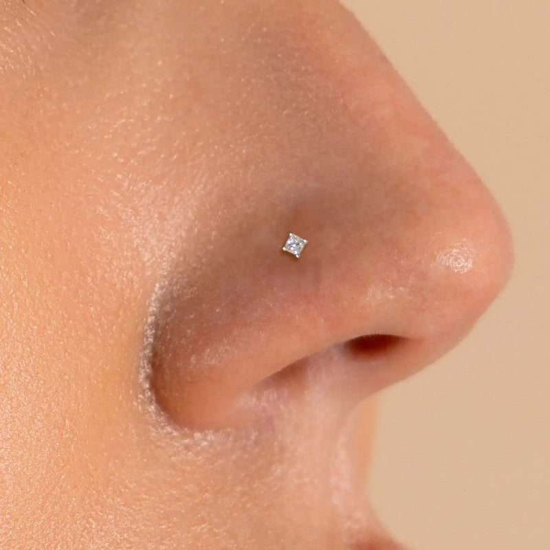1.75mm princess-cut diamond flat back stud shown in pierced nose, white gold for size reference