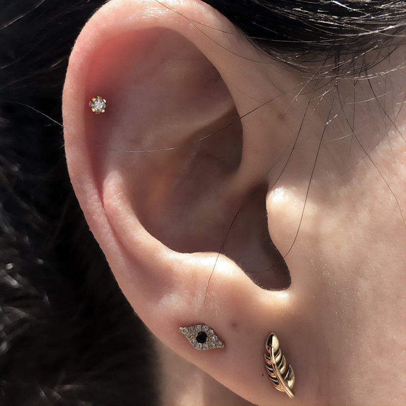 CZ flat back labret stud worn in helix cartilage piercing, styled with gold ear stack