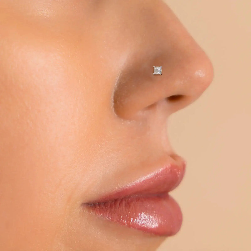 2mm princess-cut diamond flat back stud worn in nose piercing, side profile view on model