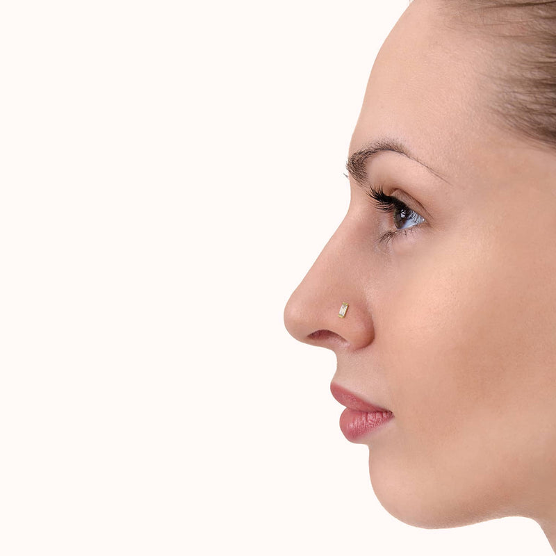 Baguette diamond 14K gold nose ring shown in pierced nostril, side profile demonstrating subtle fit and scale