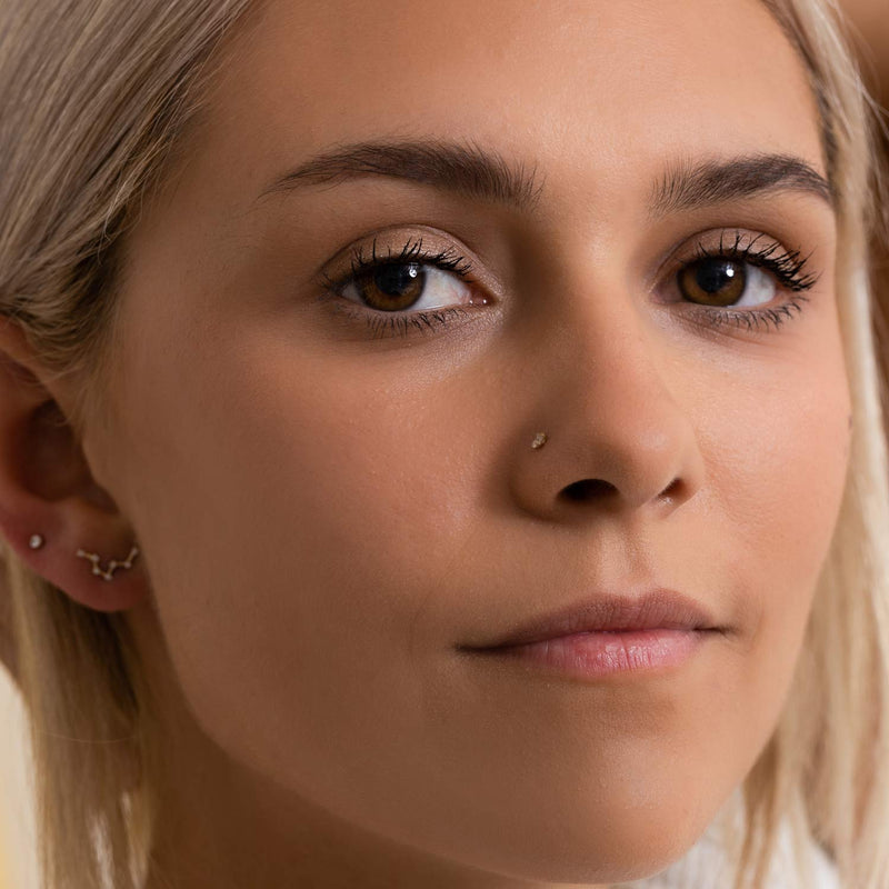 3mm diamond nose ring stud shown in piercing on blonde model facing forward, subtle everyday look