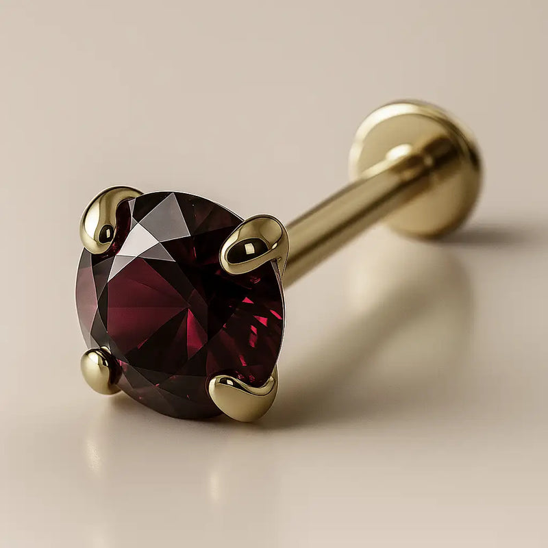 3mm garnet 14K yellow gold prong-set flat back labret, angled view showing deep red stone and flat disc