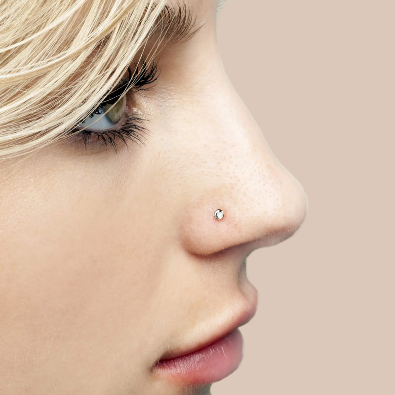 Side profile of model wearing 2mm CZ bezel flat back stud in nose piercing, rose gold tone