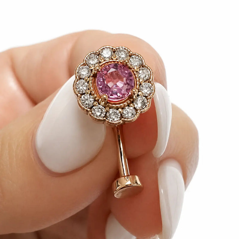 14k rose gold La Reina floating navel ring with pink sapphire and diamonds, held for size reference