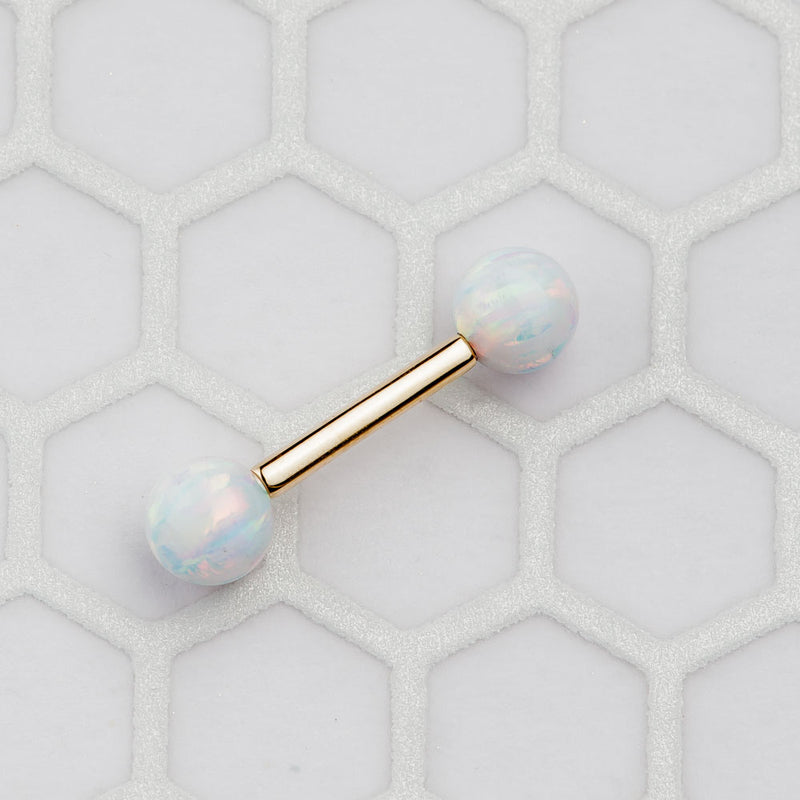 14k yellow gold opal straight barbell resting on hexagon tile surface, lifestyle flat lay