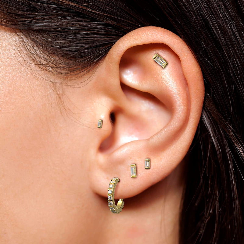 Baguette diamond push pin studs in helix, second lobe, and lobe piercings showing curated ear stack styling
