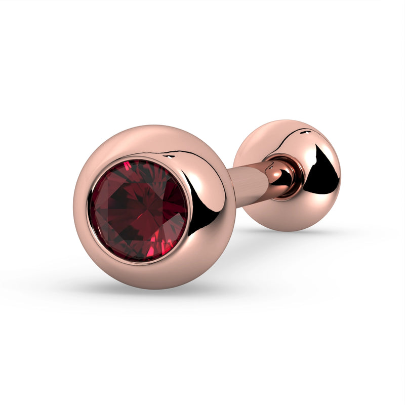 14K rose gold tongue barbell with ruby in bezel setting, angled close-up showing rich red stone