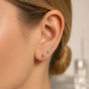 14K white gold diamond prong studs stacked in multiple lobe piercings, graduating sizes on model