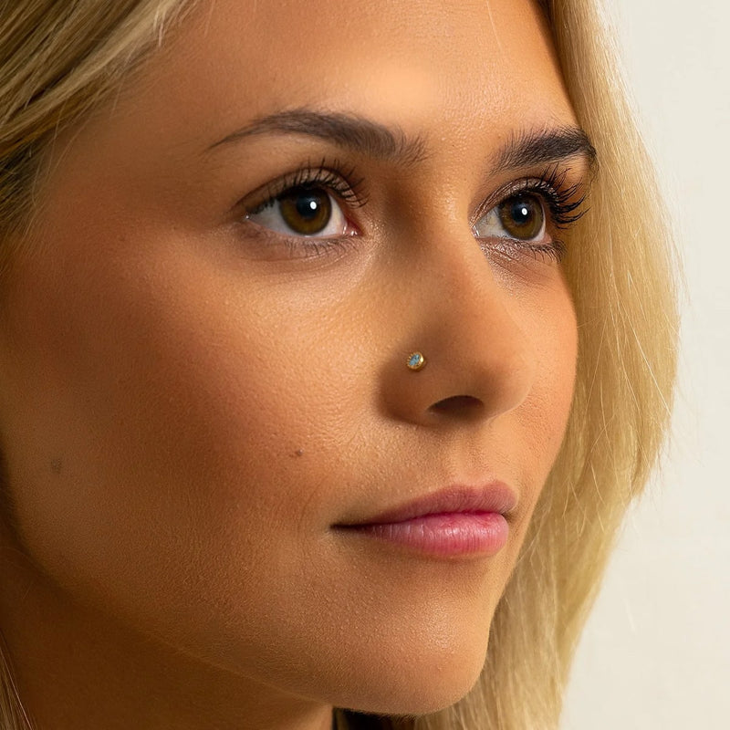 Aqua diamond milgrain bezel nose ring worn in nose piercing, front-facing model view for fit reference