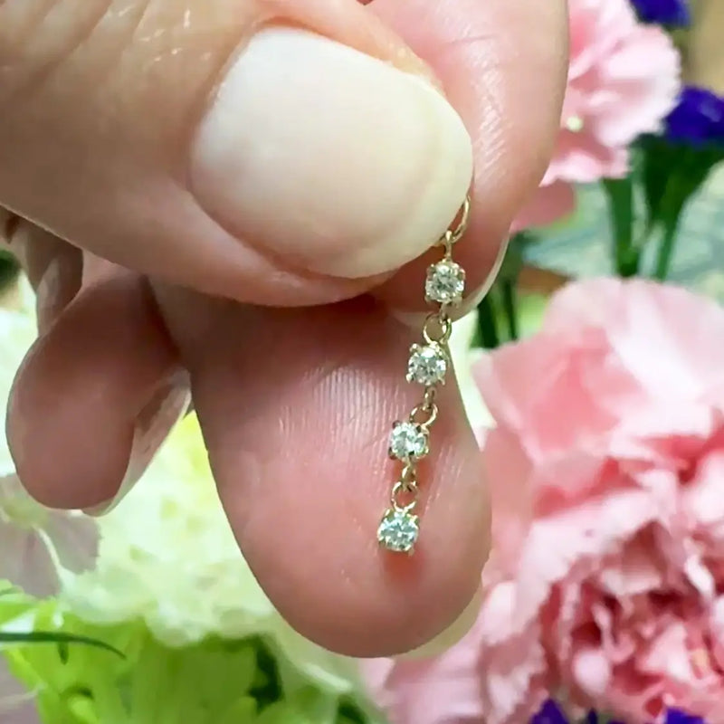 14k yellow gold brilliant drop CZ charm held between fingers to show small 13mm size and scale