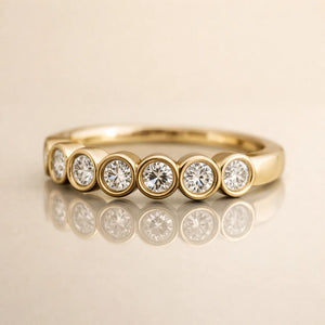 14k yellow gold bubbles seam ring with CZ bubble bezel settings, angled front view on reflective surface