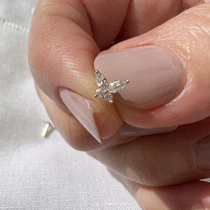 14k gold butterfly curved barbell top held between fingers to show delicate actual size