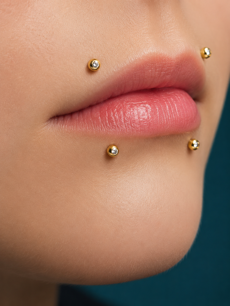 Canine bites piercing with four gold bezel-set studs, two on the upper lip and two on the lower