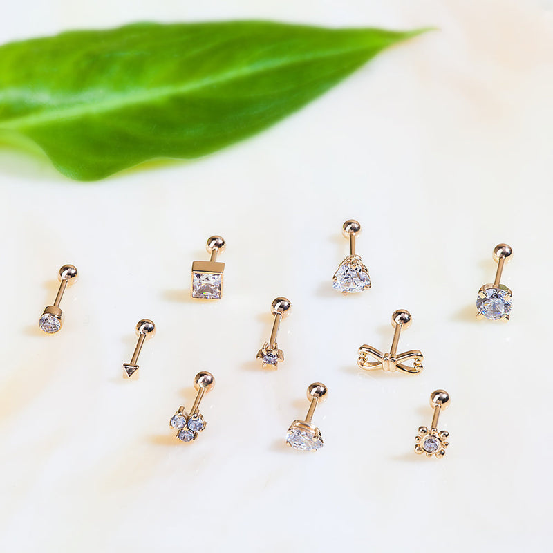 Triple diamond gold cartilage stud shown among an assortment of 14k gold piercing jewelry styles