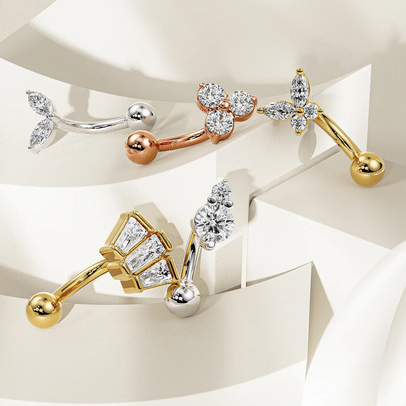 Collection of 14k gold curved barbells in yellow, rose, and white gold on tiered display