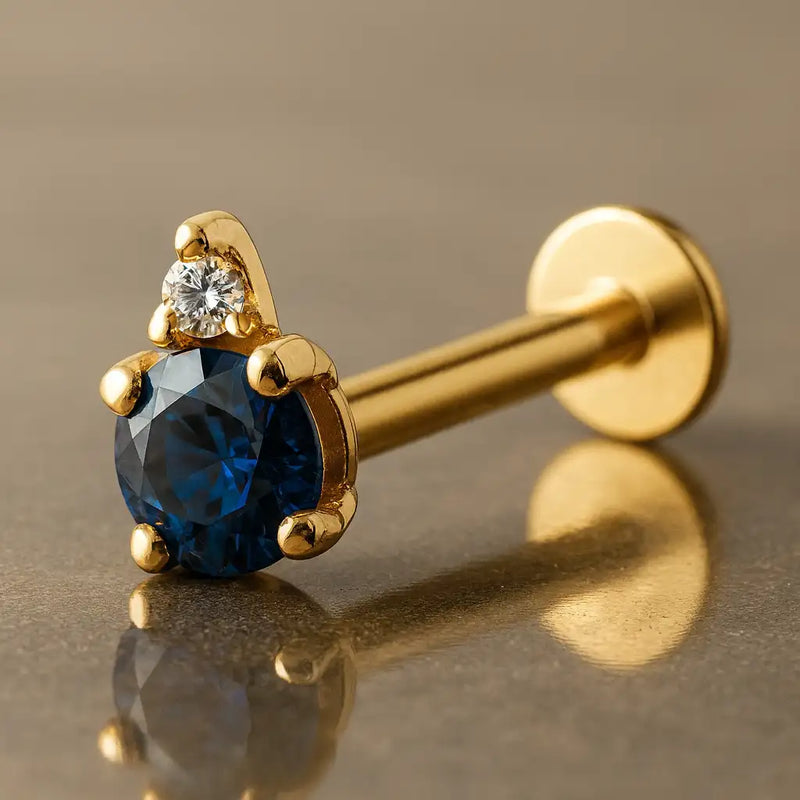 14k yellow gold flat back labret with round blue sapphire and diamond accent, angled side view