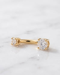 Real diamond belly rings - 14k yellow gold curved navel barbell with prong-set diamonds on white marble