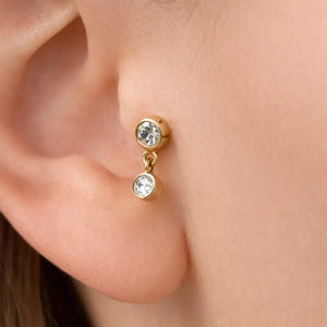 14k yellow gold bezel diamond dangle cartilage stud shown in helix piercing on model's ear