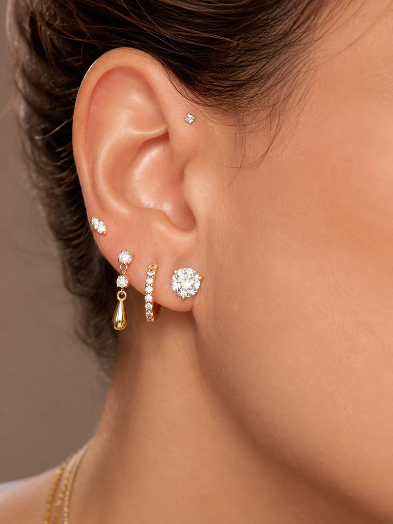 Model wearing a curated 14k gold diamond ear stack
