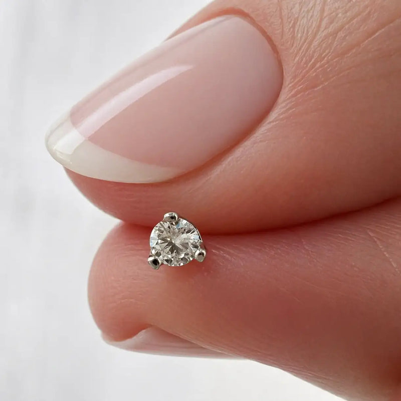 14k white gold 3-prong VS1 diamond labret end held between two fingers for size reference