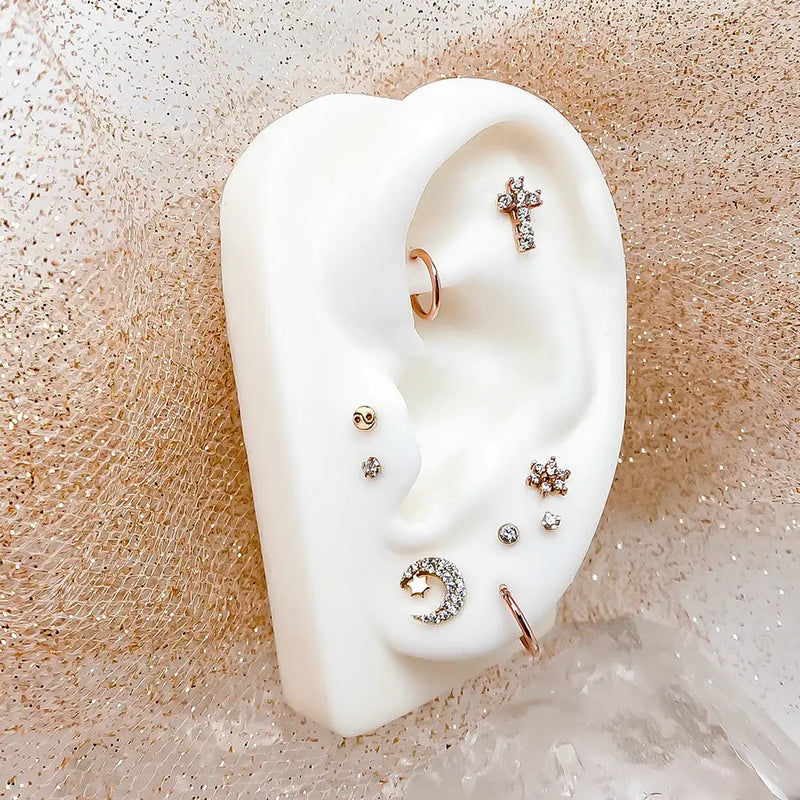 Diamond moon and star labret stud on white ear form styled in rose gold piercing cluster display
