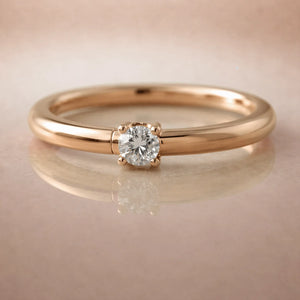 14K rose gold diamond side-set seam ring hoop with prong-set round diamond, on reflective surface