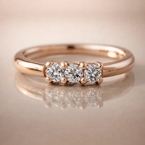 14k rose gold three-diamond seam ring hoop on reflective surface, front view