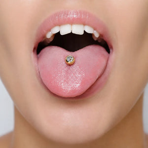 14K gold tongue barbell with white sapphire shown in pierced tongue, demonstrating fit and bezel profile