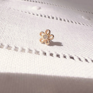 14k yellow gold dainty daisy flower push pin end shown on white linen fabric for size reference
