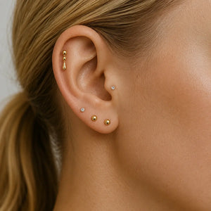 14k yellow gold dew drop labret shown in helix piercing with curated ear stack for fit reference