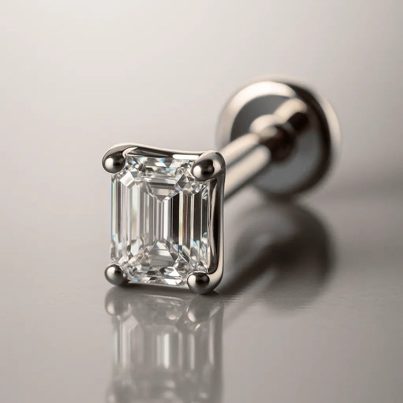 14k white gold emerald-cut diamond flat back labret stud, angled studio shot with reflective surface