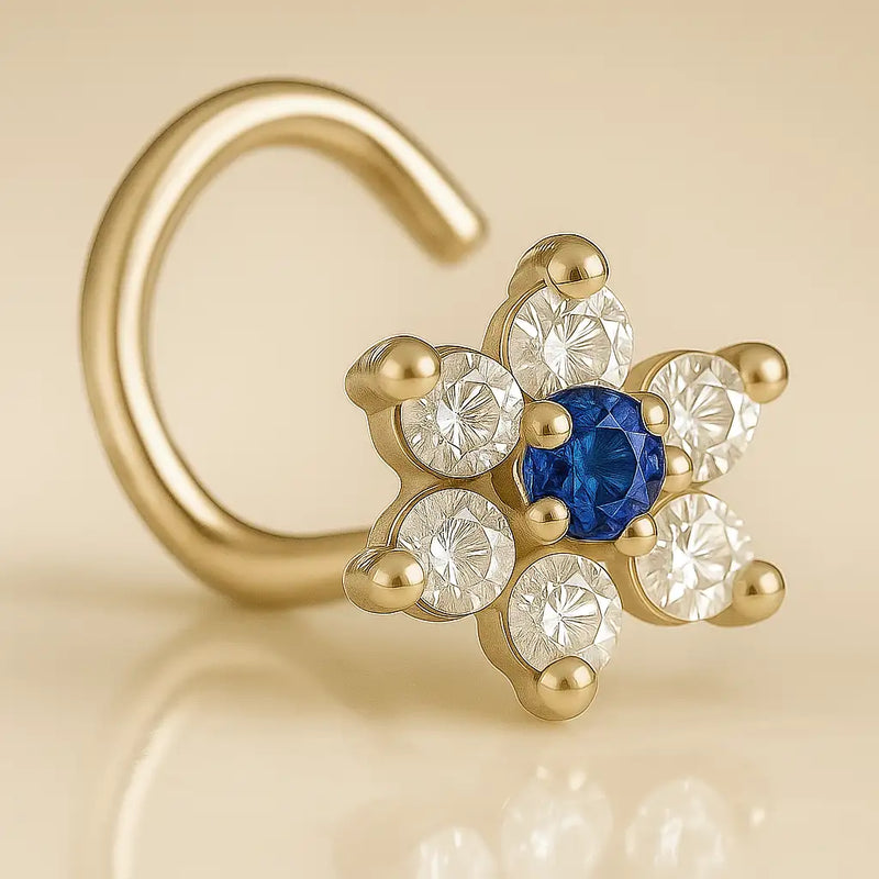 14K yellow gold CZ flower nose ring twist with blue sapphire center CZ, angled studio view