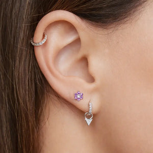 Purple CZ flower flat back stud shown in lobe piercing on model with curated ear stack