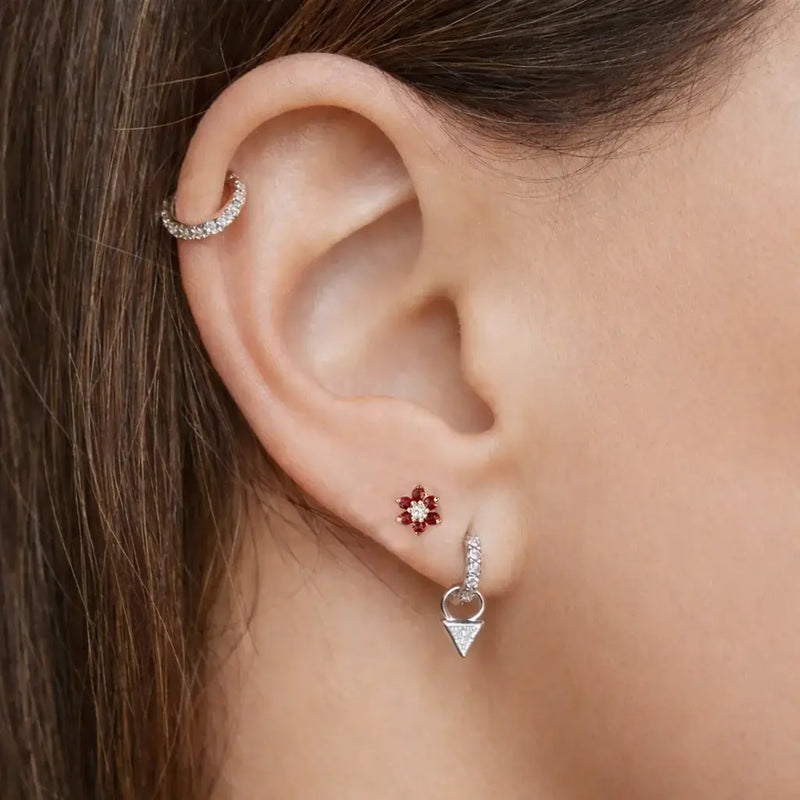 Red CZ flower flat back labret stud worn in lobe piercing on model, styled ear stack view