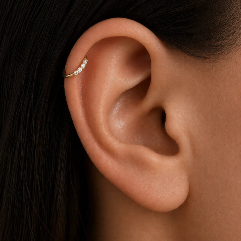Four-diamond 14K gold seam ring hoop shown in a helix piercing, demonstrating side-set fit