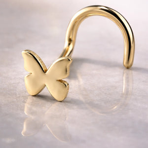 14K yellow gold butterfly nose ring twist style, close-up on reflective surface showing wing detail