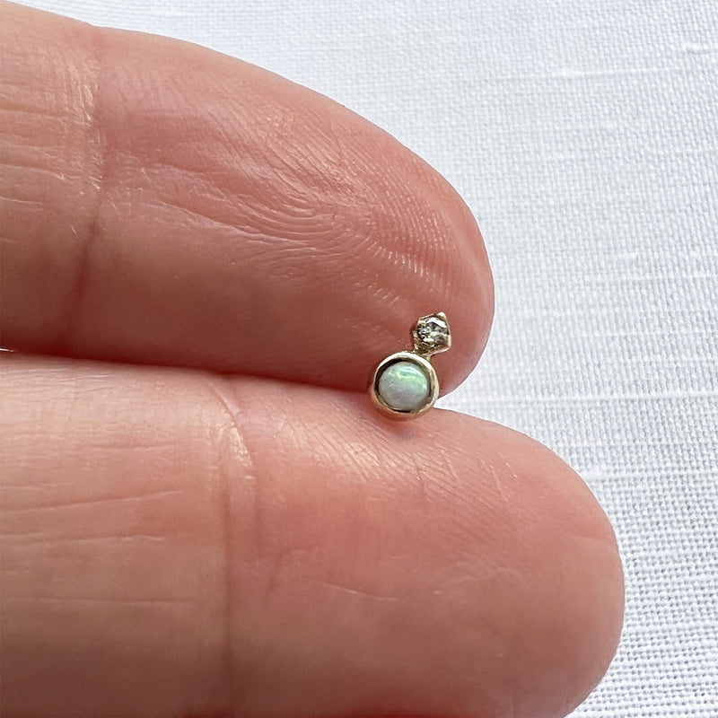 14k gold opal and diamond threadless stud end held on fingertip for actual size reference