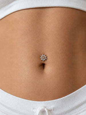 Close-up of a model's navel wearing the Jasmine diamond floating navel ring - a diamond flower cluster in 14k gold