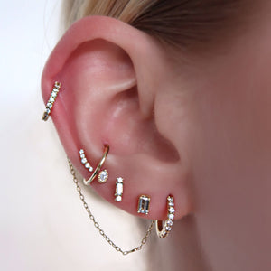 Eliza baguette diamond push pin end worn in a curated ear with multiple gold cartilage piercings