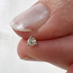 2.5mm VS1 diamond nose ring end held between fingers to show actual tiny size