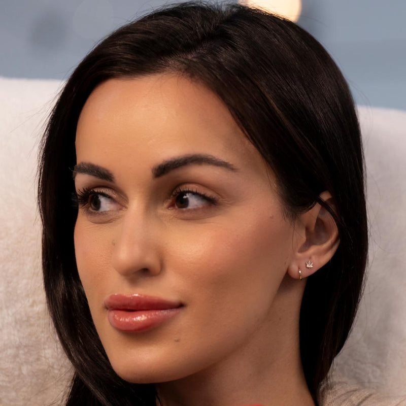 14k gold 10mm huggie hoop shown on model's ear, demonstrating close, minimal fit against the lobe