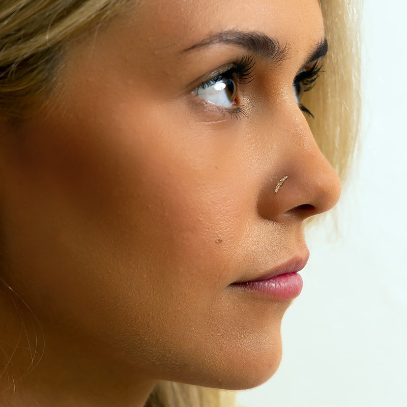 Side profile of mini climber CZ nose ring worn in model's nose piercing, showing fit and scale