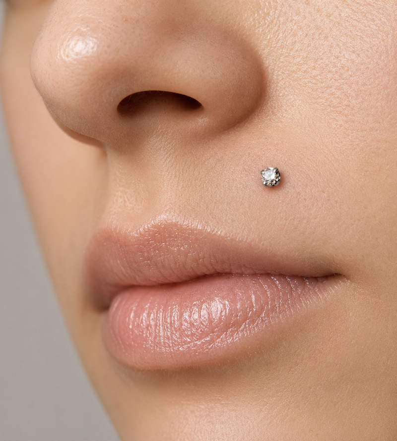 Monroe piercing with a diamond flat back stud on the upper lip