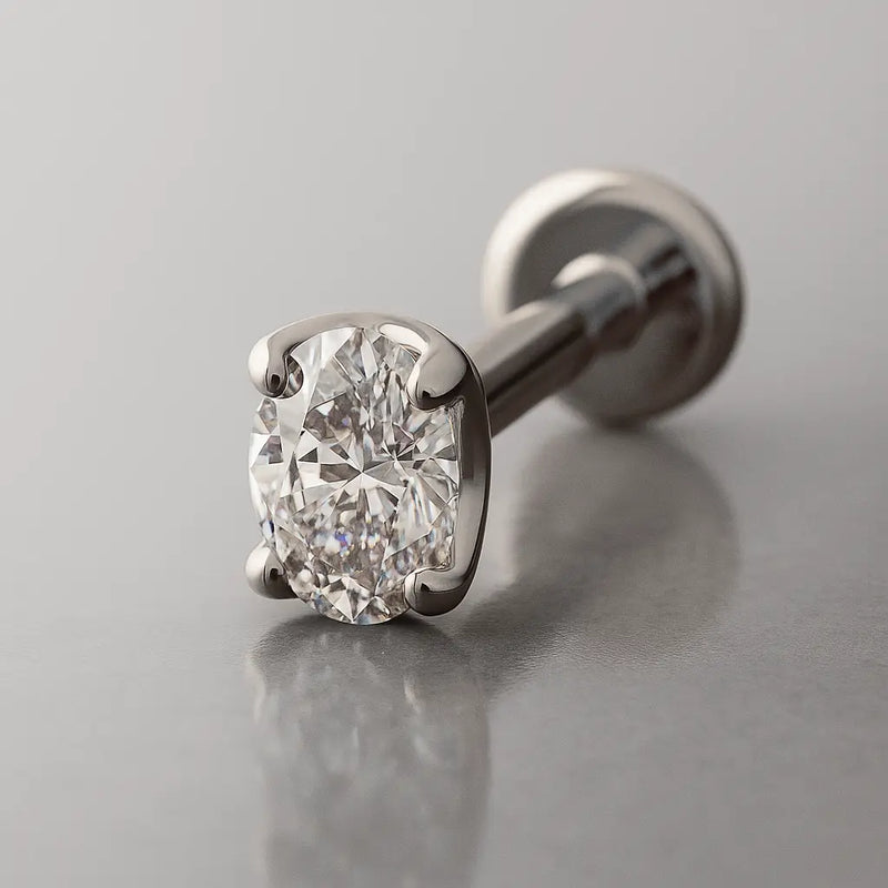 14k white gold 3mm oval-cut diamond flat back labret, angled studio shot highlighting 4-prong setting