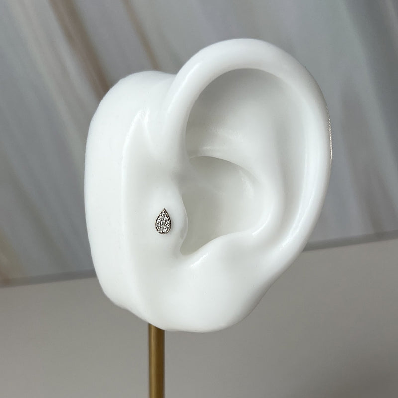 Diamond pavé teardrop flat back earring shown in lobe piercing on ceramic ear model for size reference