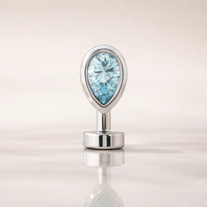 14k white gold floating navel ring with aquamarine teardrop stone, front view on reflective surface