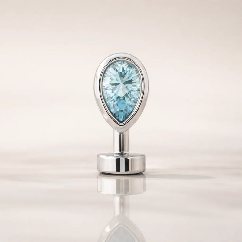 14k white gold floating navel ring with aquamarine teardrop stone, front view on reflective surface