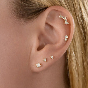 Diamond pear climber flat back stud worn in helix piercing, styled with multiple gold cartilage earrings