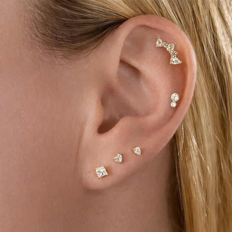 Diamond pear climber flat back stud worn in helix piercing, styled with multiple gold cartilage earrings