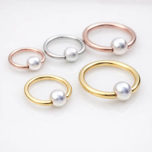Pearl captive bead rings styled in yellow gold, rose gold, and silver tones showing various ring and pearl sizes